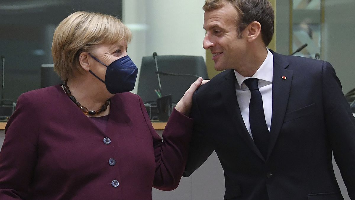 French President Emmanuel Macron, right, and German Chancellor Angela Merkel during a round table meeting at an EU summit in Brussels, Oct. 22, 2021. 