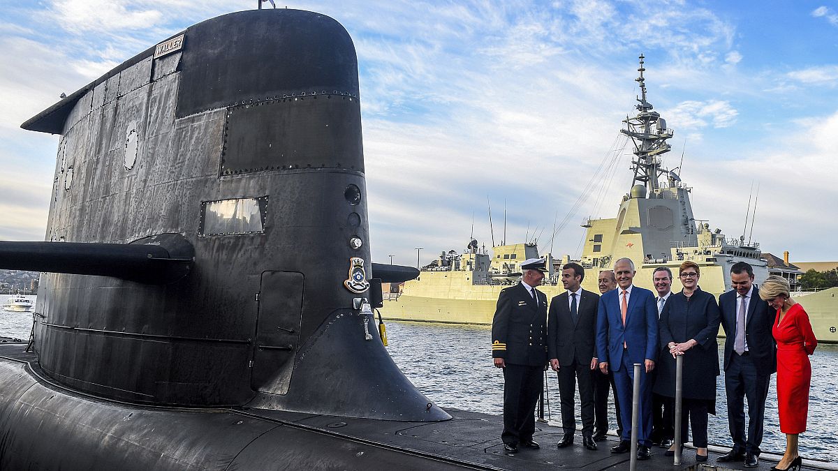 FILE: French President Emmanuel Macron, second left, and Australian Prime Minister Malcolm Turnbull, centre, stand on the submarine HMAS Waller in Sydney.