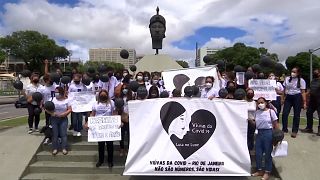 Group posing for a picture at the Zumbi Monument with black balloons and banners