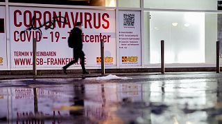 Járókelő egy volt tesztelési központ előtt, Frankfurtban