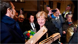 المستشارة الألمانية أنغيلا ميركل والرئيس الفرنسي إيمانويل ماكرون يتبادلان الزهور والهدايا خلال زيارتها الوداعية لفرنسا، بون، 3 نوفمبر 2021