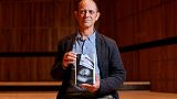 South African author Damon Galgut poses with his book 'The Promise' shortlisted for the 2021 Booker Prize for Fiction  in London on October 31, 2021.