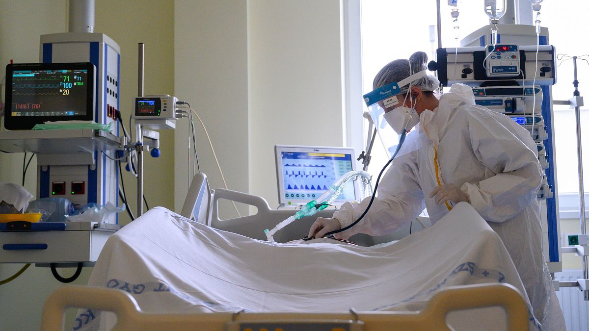 Védőfelszerelést viselő orvos egy beteget vizsgál egy székesfehérvári kórházban 2021. április 28-án.