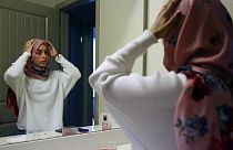 Amerikai muszlim nő igazítja meg fejkendőjét, mielőtt a boltba indul