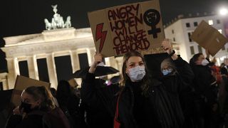 A woman from Poland shows a poster as she attends a protest against recent tightening of Poland's restrictive abortion law, in front of the Brandenburg Gate in Berlin, Germany