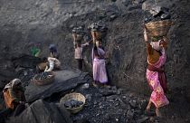 People carry baskets of coal scavenged illegally at an open-cast mine in the village of Bokapahari in the eastern Indian state of Jharkhand.