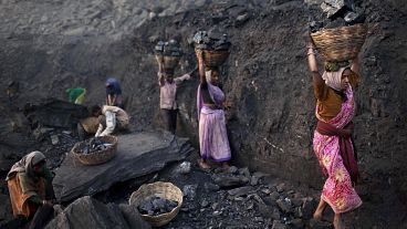 People carry baskets of coal scavenged illegally at an open-cast mine in the village of Bokapahari in the eastern Indian state of Jharkhand.