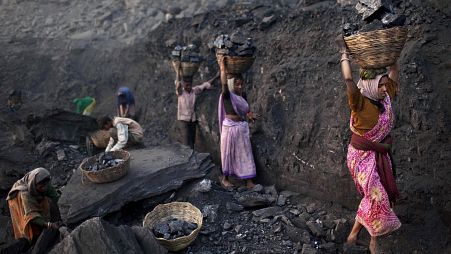 People carry baskets of coal scavenged illegally at an open-cast mine in the village of Bokapahari in the eastern Indian state of Jharkhand.