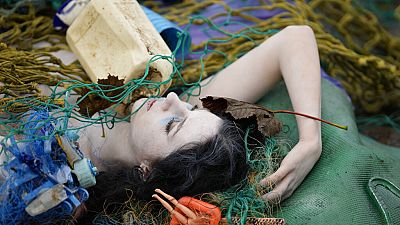 A protester dressed as a dead merepeole attends a demonstration against bottom fishing by Extinction Rebellion, ahead of COP26, Glasgow, Scotland, Saturday, Oct. 30, 2021.