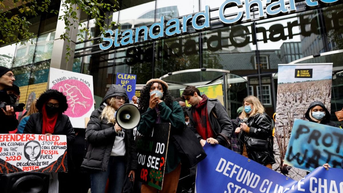 Gli attivisti per il clima, tra cui Dominique Palmer, manifestano, davanti alla sede della banca Standard Chartered a Londra (29 ottobre 2021)