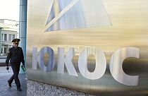 A police officer patrols near the headquarters of the bankrupt oil giant OAO Yukos during an auction of shares in Rosneft that had been owned by Yukos, Moscow, Tuesday March 2