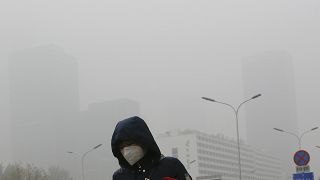 سيدة تليس كمامة لحماية نفسها من التلوث في بكين (أرشيف)