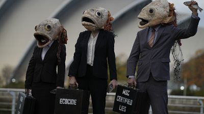 نشطاء مجموعة "أوشن ريبليون" البيئية ويرتدون أقنعة رأس الأسماك في وقفة احتجاجية ضد مجلس الإشراف البحري، على هامش قمة المناخ "كوب26" الأممي في غلاسكو
