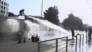 Police fire water cannon at protesting firefighters gathered outside Greece's Climate Change and Civil Protection Ministry in Athens on Friday, Nov. 5, 2021.