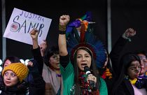 Indigenous people from Brazil speak from the stage during a demonstration in Glasgow, Scotland, Friday, Nov. 5, 2021.