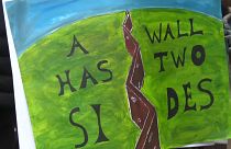 Надпись на плакате: "У стены есть две стороны"