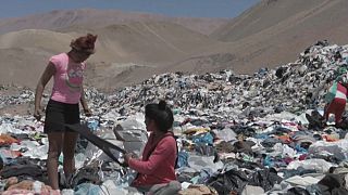 Dos mujeres buscan prendas en el vertedero de Iquique, Chile