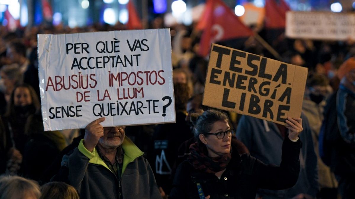 Demonstrators hold a banner reading 'why are you accepting abusive electricity taxes without complaining?' during a protest against rising electricity prices, in Barcelona.