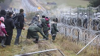 Migrants from the Middle East and elsewhere break down the fence as they gather at the Belarus-Poland border near Grodno, Belarus, Monday, Nov. 8, 2021.