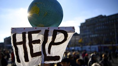 A banner held aloft at climate protests in Lausanne, Switzerland on Saturday