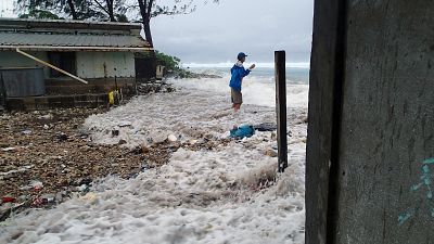 This photo taken on March 3, 2014 shows a resident surrounded by the on-rushing high tide energized by a storm surge that damaged a number of homes across Majuro.