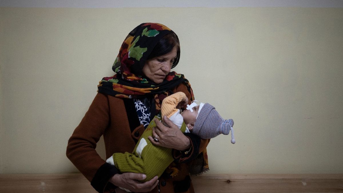 Simien Arian holds her malnourished nine-month-old grandchild Maaz in the Indira Gandhi hospital in Kabul, Afghanistan, Monday, Nov. 8, 2021. 