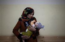 Simien Arian holds her malnourished nine-month-old grandchild Maaz in the Indira Gandhi hospital in Kabul, Afghanistan, Monday, Nov. 8, 2021.