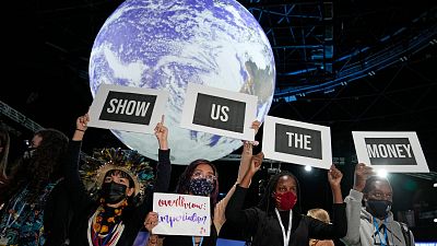 Climate activist Vanessa Nakate, second right, and other activists engage in a 'Show US The Money' protest at  COP26 in Glasgow, Scotland, Monday, Nov. 8, 2021.