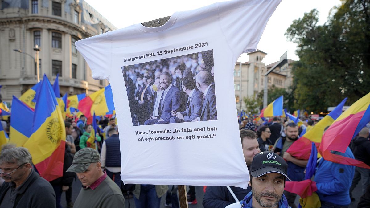 A man holds a t-shirt with a picture showing Romania's president Klaus iohannis at the ruling Liberal Party congress.