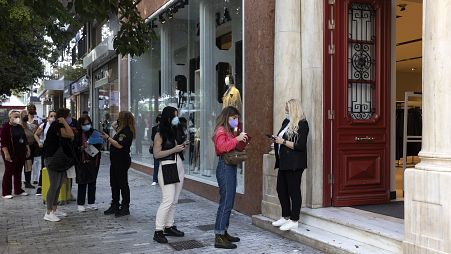People line up so they can be checked for their Covid-19 vaccination certificates in order to be allowed to enter a shop in Athens, Greece, Saturday, Nov. 6, 2021.