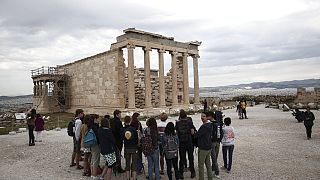 Des touristes devant  le temple Erechtheion sur la colline de l'Acropole à Athènes