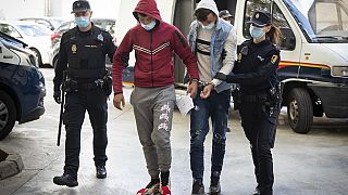 Two of the suspects are escorted by police officers to the courthouse in Palma de Mallorca.
