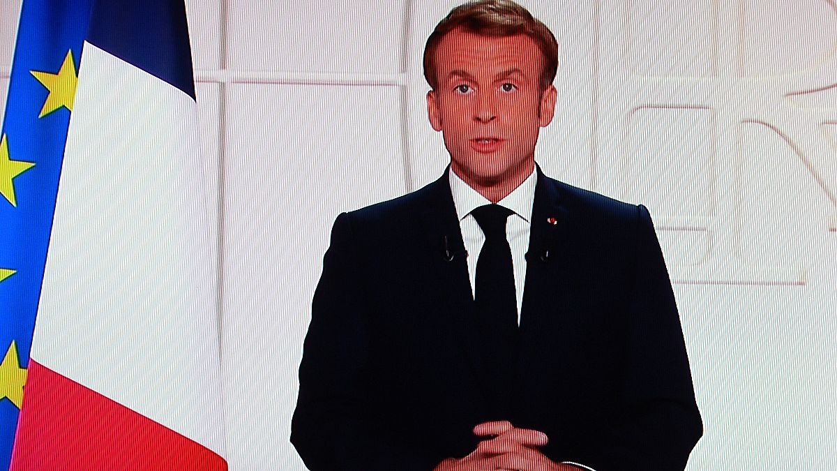 France's President Emmanuel Macron appears on a TV screen as he addresses to the nation on Covid-19 and reforms in Paris on November 9, 2021.