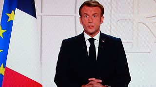 France's President Emmanuel Macron appears on a TV screen as he addresses to the nation on Covid-19 and reforms in Paris on November 9, 2021.