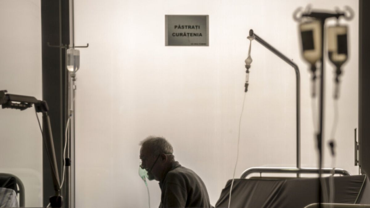 Un paciente positivo de COVID-19 respira a través de una máscara de oxígeno en la sala de espera del Hospital Universitario de Urgencias, en Bucarest.