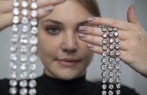 A Christie's employee holds up a pair of diamond bracelets once owned by Marie Antoinette of France, in silver and yellow gold, circa 1776, during a preview at the Christie's,