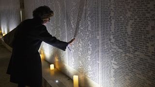 Une parent de victimes du régime nazi visite le Mur des noms après la cérémonie d'inauguration, à Vienne (Autriche) le 9 novembre 2021.
