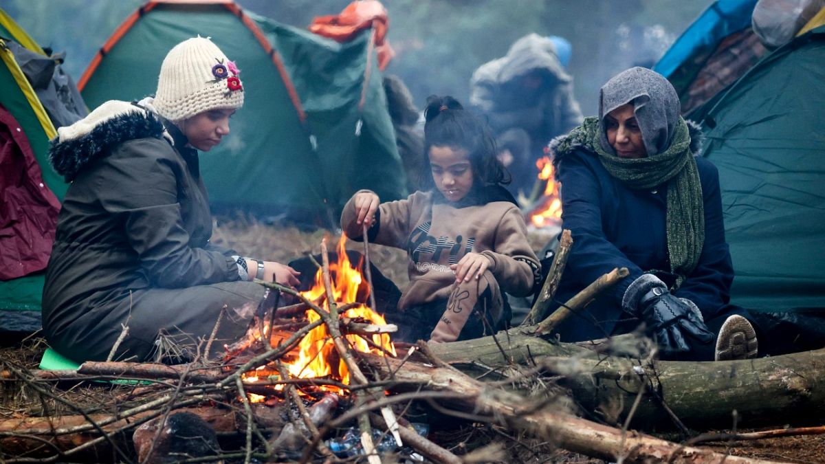 Migrants from the Middle East and elsewhere warmup at the fire gathering at the Belarus-Poland border near Grodno, Belarus, Wednesday, Nov. 10, 2021. 
