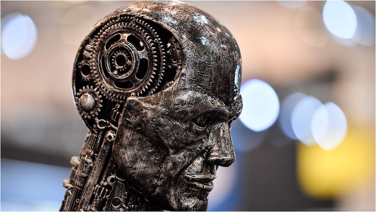 مجسم لرأس إنسان معدني مصنوع من أجزاء المحرك يرمز إلى الذكاء الاصطناعي "AI" في معرض "إيسن موتور شو"  في مدينة إيسن بألمانيا، 29 نوفمبر 2019 