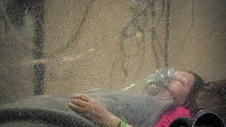 Paciente em Bucareste recebe oxigénio, isolada por cortina de plástico