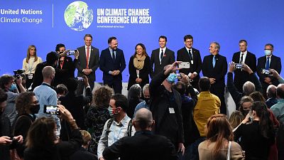 Ministers and representatives of the "Beyond Oil and Gas Alliance" pose on stage at the COP26