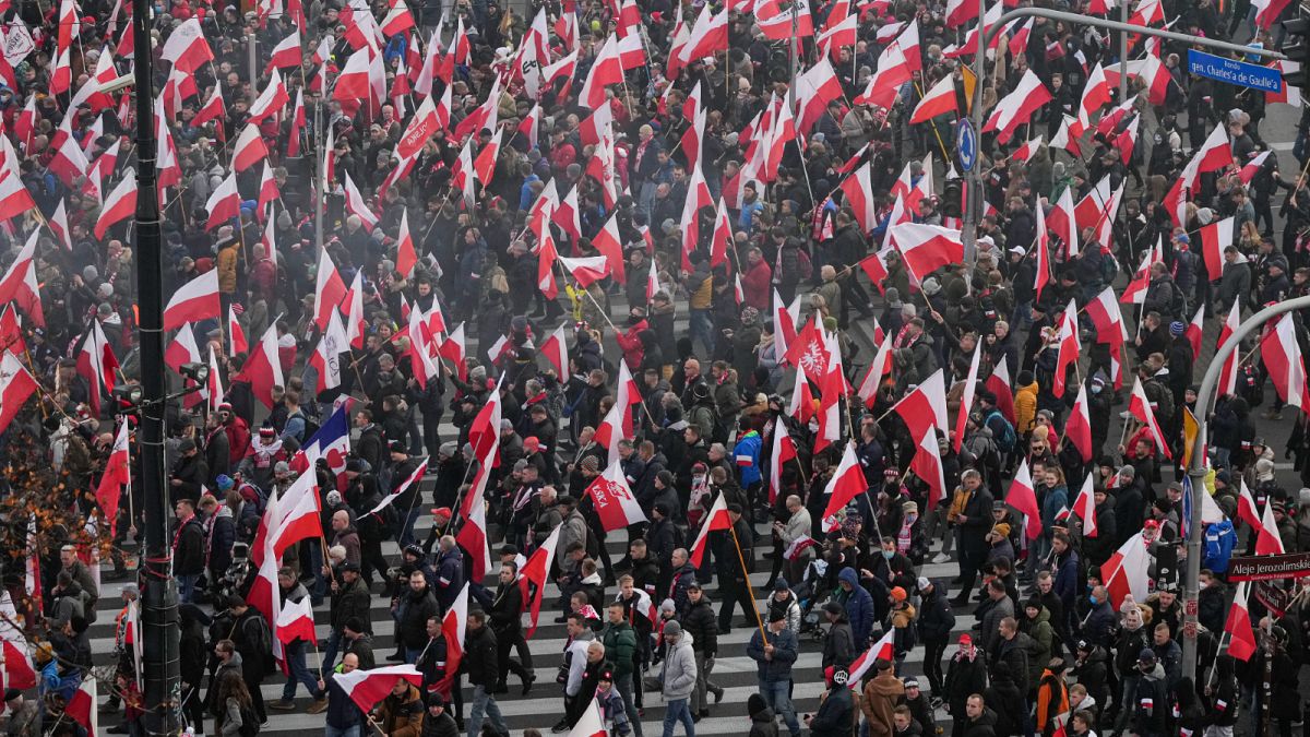 متظاهرون يرفعون الأعلام البولندية خلال مسيرة عيد الاستقلال السنوية التي تحولت بسبب مشاركة الجماعات اليمينية إلى أعمال عنف في وارسو.