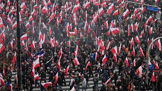 متظاهرون يرفعون الأعلام البولندية خلال مسيرة عيد الاستقلال السنوية التي تحولت بسبب مشاركة الجماعات اليمينية إلى أعمال عنف في وارسو.