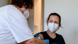 Egy nő megkapja a német-amerikai fejlesztésű Pfizer-BioNTech koronavírus elleni oltóanyag, a Comirnaty-vakcina harmadik, emlékeztető adagját