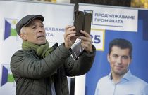 A supporter of the Political Party "We Continue the Change" takes pictures during an event in central Sofia, Wednesday, Nov. 10, 2021.