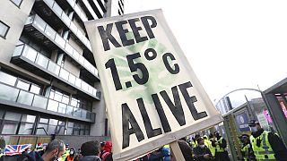 A placard reminds world leaders of their climate commitments at a COP26 demonstration in Glasgow on Friday