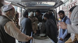 Afghan volunteers help place a wounded man on a stretcher at a hospital after the explosion.