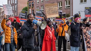 The foreman of action group Kick Out Zwarte Piet, Jerry Afriyie, centre left, addresses the bystanders during protest against Black Pete.
