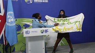 Podium in Glasgow gestürmt. Auf dem Plakat steht: "Das Klima ändert sich. Warum andern wir uns nicht?"