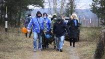 متطوعون من بيلاروسيا يحملون مريضًا على الحدود بين بولندا وبيلاروس بالقرب من غرودنو.